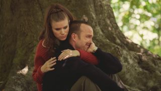 Kate Mara comforts a crying Aaron Paul in the woods in Black Mirror: Beyond The Sea.