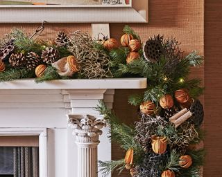 Pinecones and oranges on fireplace garland