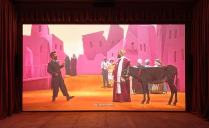 Men, donkey and pink buildings in film still from Wael Shawky, Drama 1882, 2024, at Egyptian Pavilion, Venice Biennale 2024