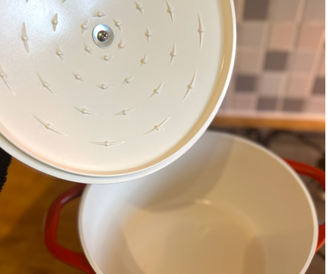 The lid of a Dutch oven lifted above the pot.