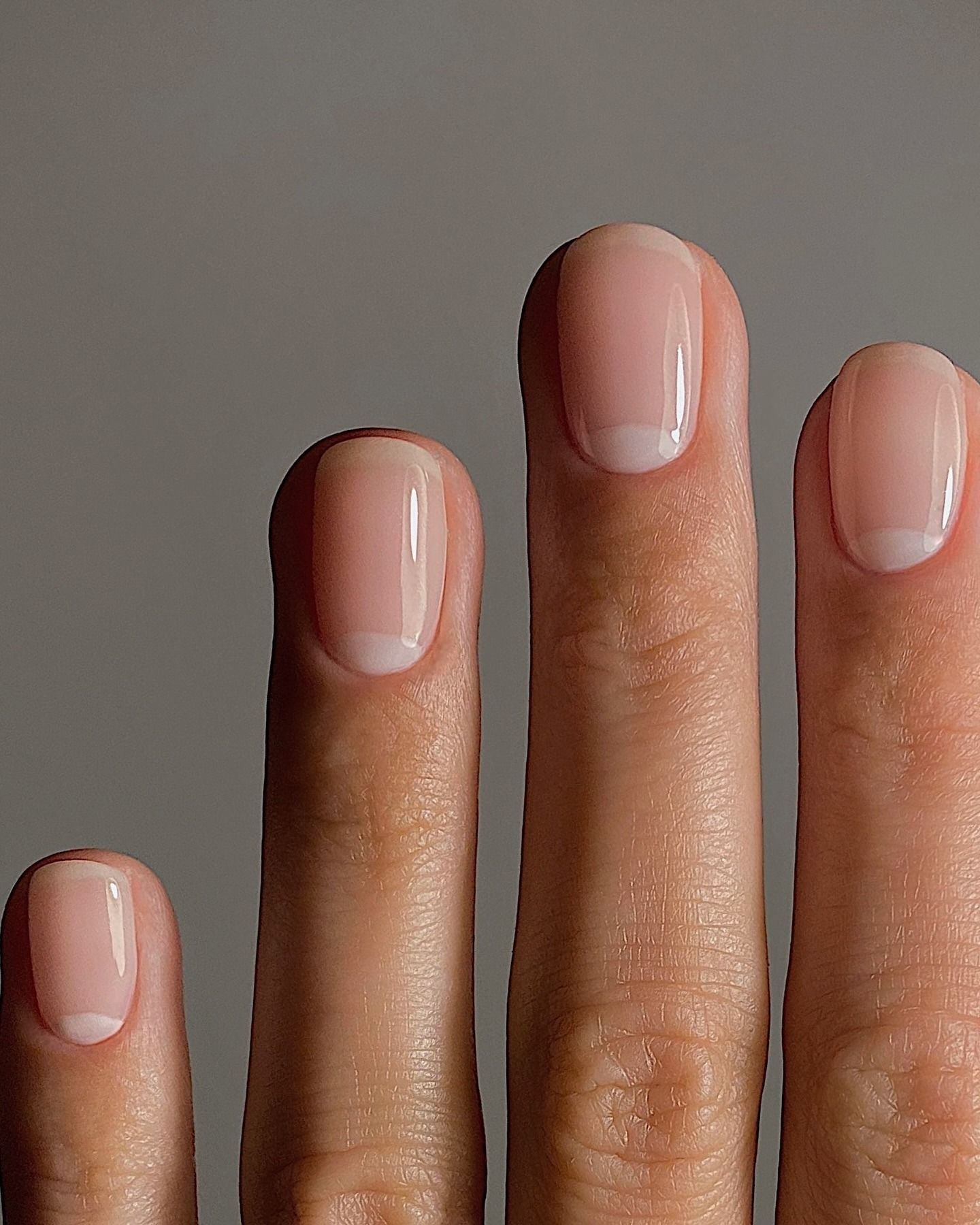 A rounded nail with a subtle French manicure design