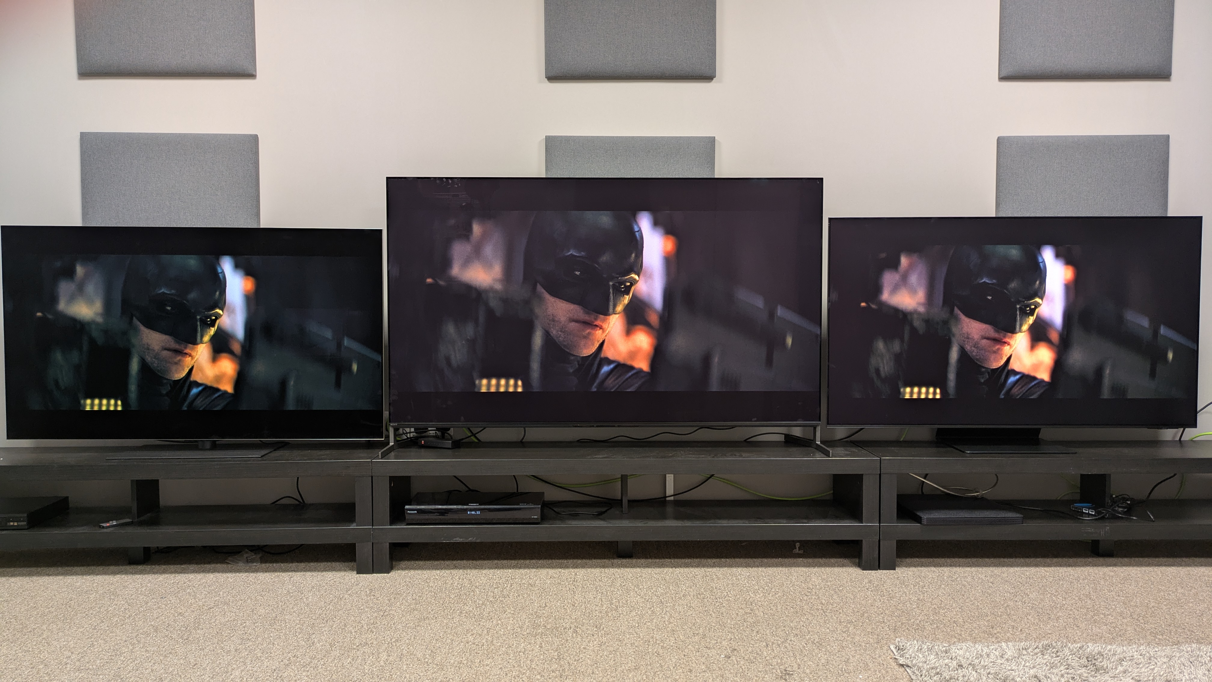 LG G5 (left) Sony Bravia 8 II (middle) and Samsung S95F (left) with face of Batman on screen from The Batman with Sony's brighter tone mapping setting 