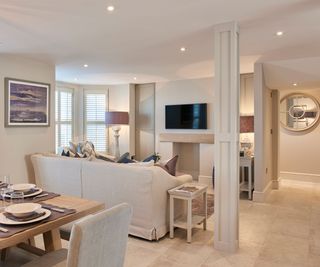 neutral open plan living room with stone flooring and downlighters