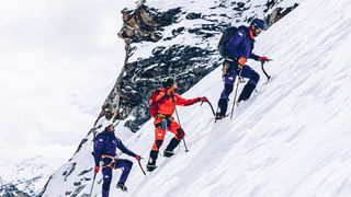 Three men on snowy mountainside wearing The North Face Summit Series kit