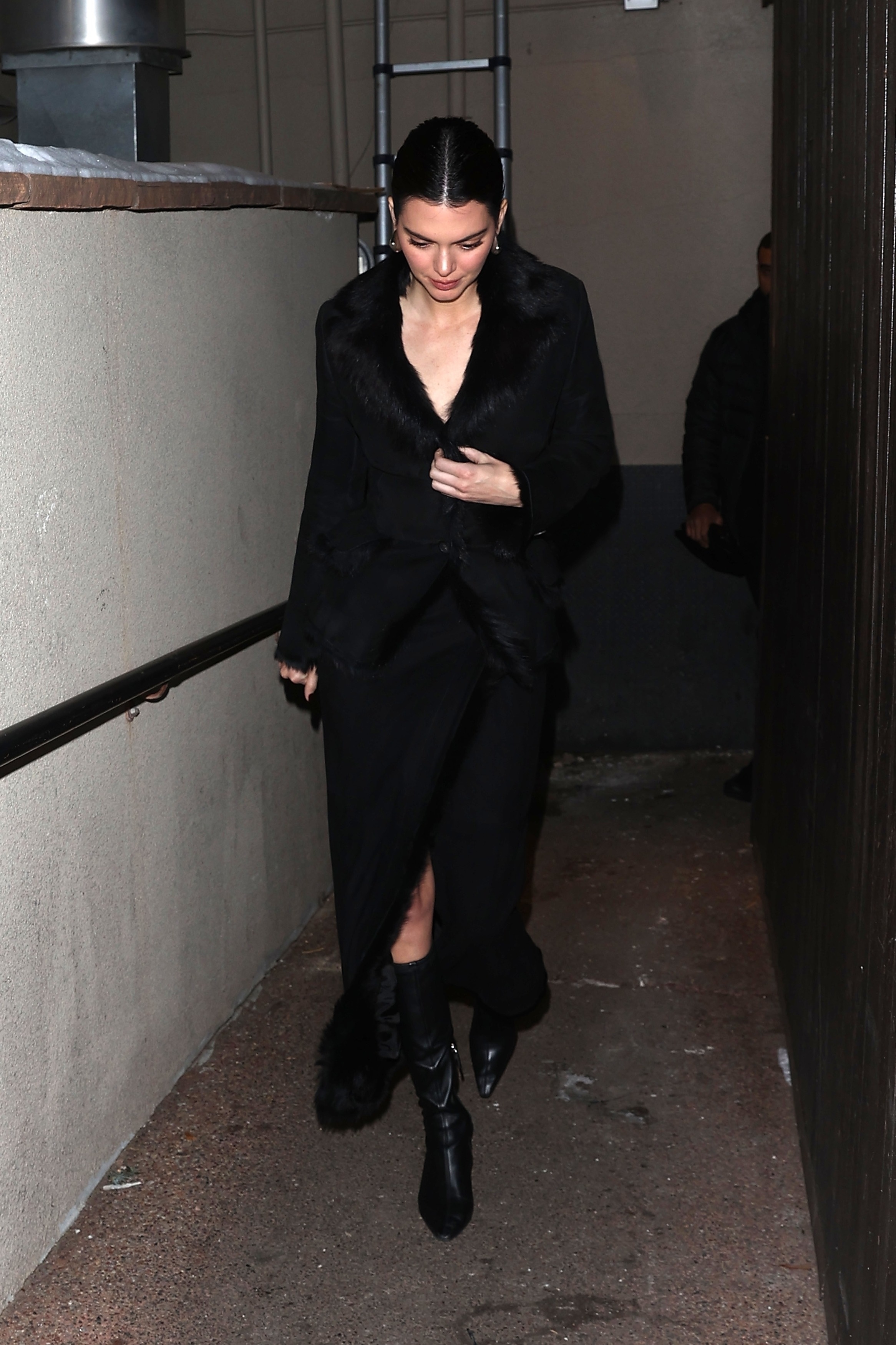 Kendall Jenner wears a fur coat, fur skirt, and black sock boots.