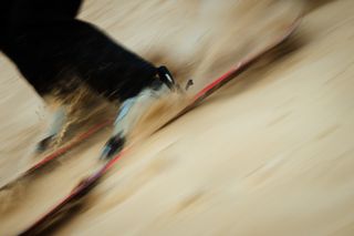 A slow shutter speed shot of a skier skiing through the dunes