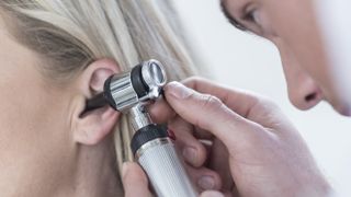 Doctor using the best otoscope to examine a woman's ear 