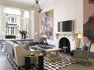 A modern apartment living room with artwork and statement geometric print rug.