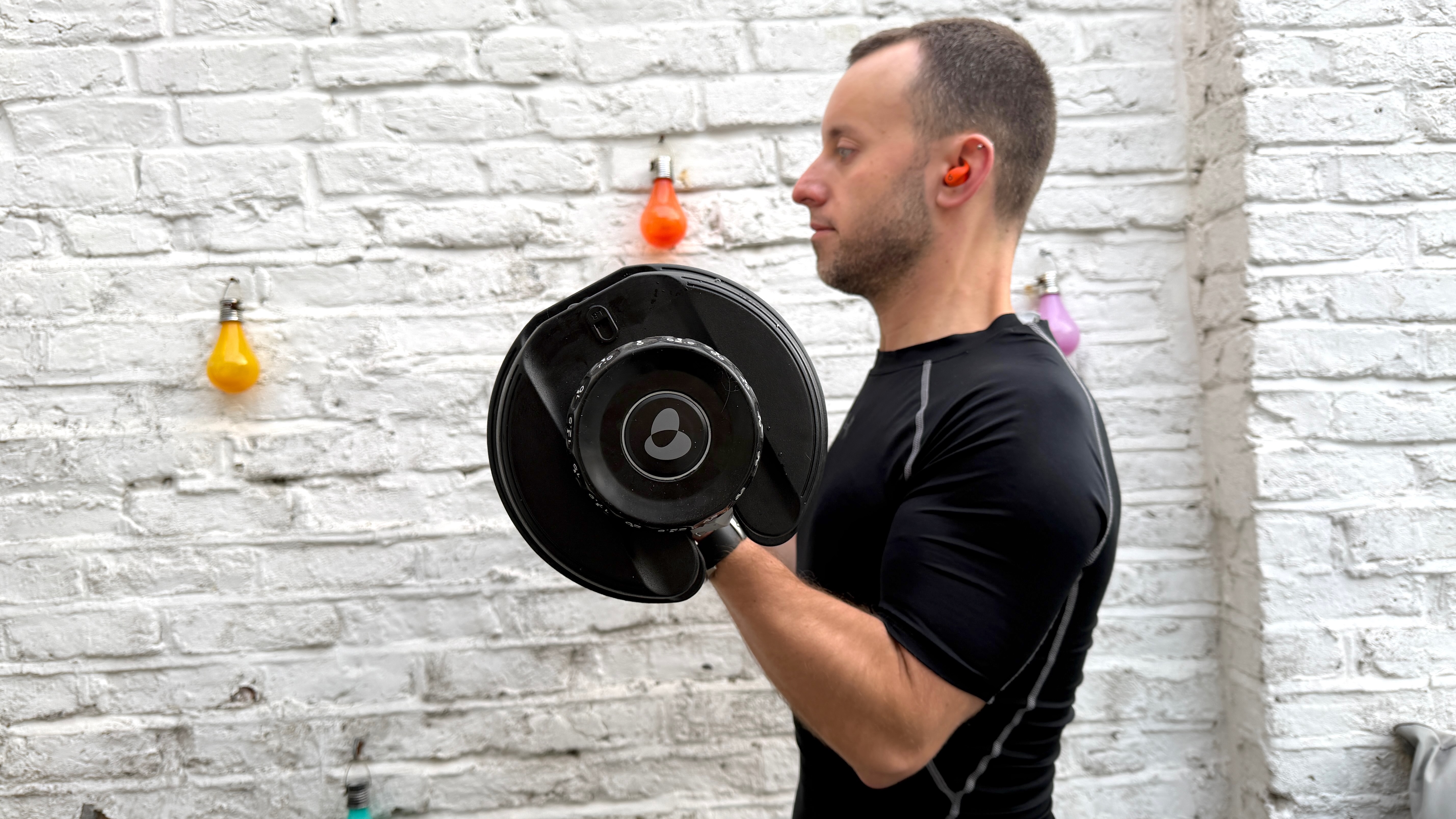 James Frew working out with the BowFlex Results Series 552 SelectTech Dumbbells in front of a painted white wall