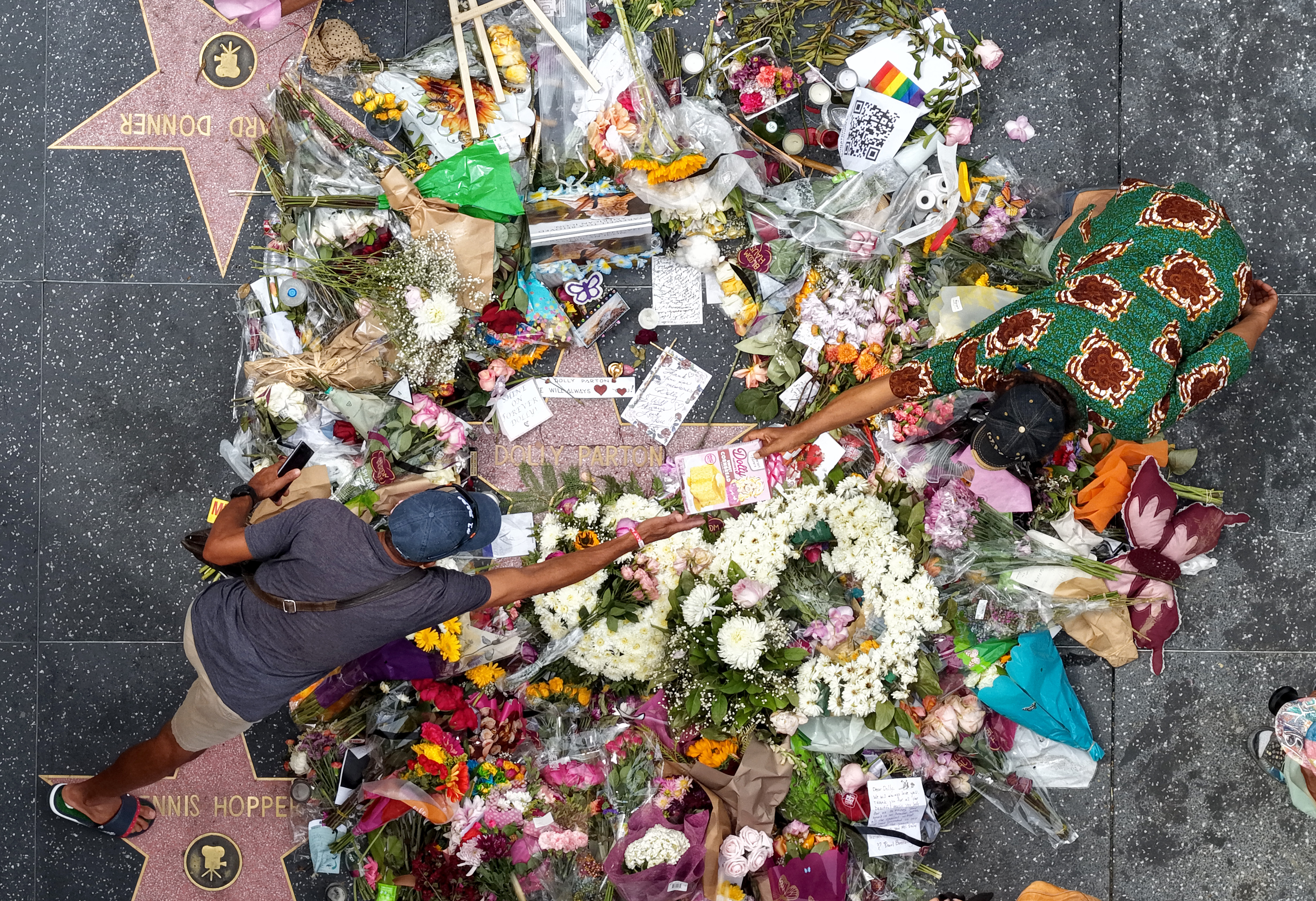In an aerial view, flowers and remembrances surround Dolly Parton's star on the Hollywood Walk of Fame on August 27, 2026 in Los Angeles, California. Country music star Dolly Parton died on Tuesday at age 80 after a six-decade career, earning 10 Grammy Awards and 25 no. 1 country hits, also becoming known for her philanthropy. (Photo by Justin Sullivan/Getty Images)