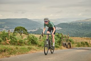 Female cyclist riding out of the saddle on a steep climb