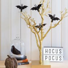 White walls with a gold tree and black bat decorations