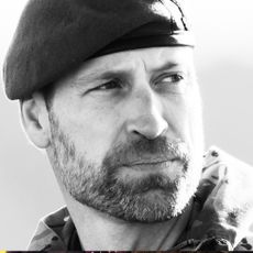 A black and white photo of Prince William wearing a beret and looking to the right with a serious expression