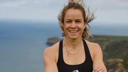 Ultra runner Elsey Davis smiles at the camera with the South West Coast Path in the background