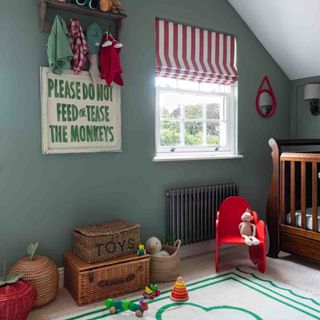 Green eaves child's bedroom with toys, striped blind and wooden crib