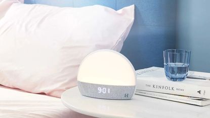 A Hatch Sunrise Alarm Clock next to a bedside table