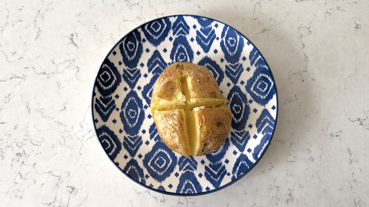 Potato baked using Ninja Crispi Microwave, split open and ready for fillings