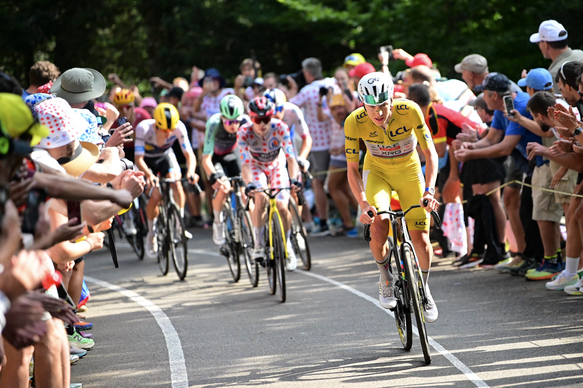 UAE Team Emirates - XRG's Slovenian rider Tadej Pogacar wearing the overall leader's yellow jersey attacks to take the lead in a lone breakaway ahead of Team Visma | Lease a Bike team's Danish rider Jonas Vingegaard wearing the climber's dotted "King of the Mountains" jersey in the final kilometers of the 14th stage of the 113th edition of the Tour de France cycling race, 155,3 km between Mulhouse and Le Markstein in the Vosges mountains, on July 18, 2026. (Photo by Bernard PAPON / POOL / AFP)