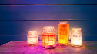 How to save on your electric bill: Image shows four candles in mason jars.