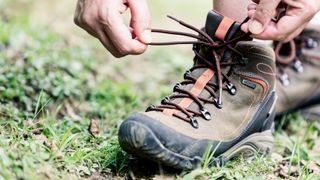 Close up of a hiker tying the laces on their hiking boots