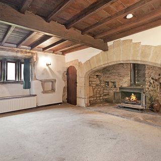 inglenook fireplace with white wall and wooden beams on ceiling