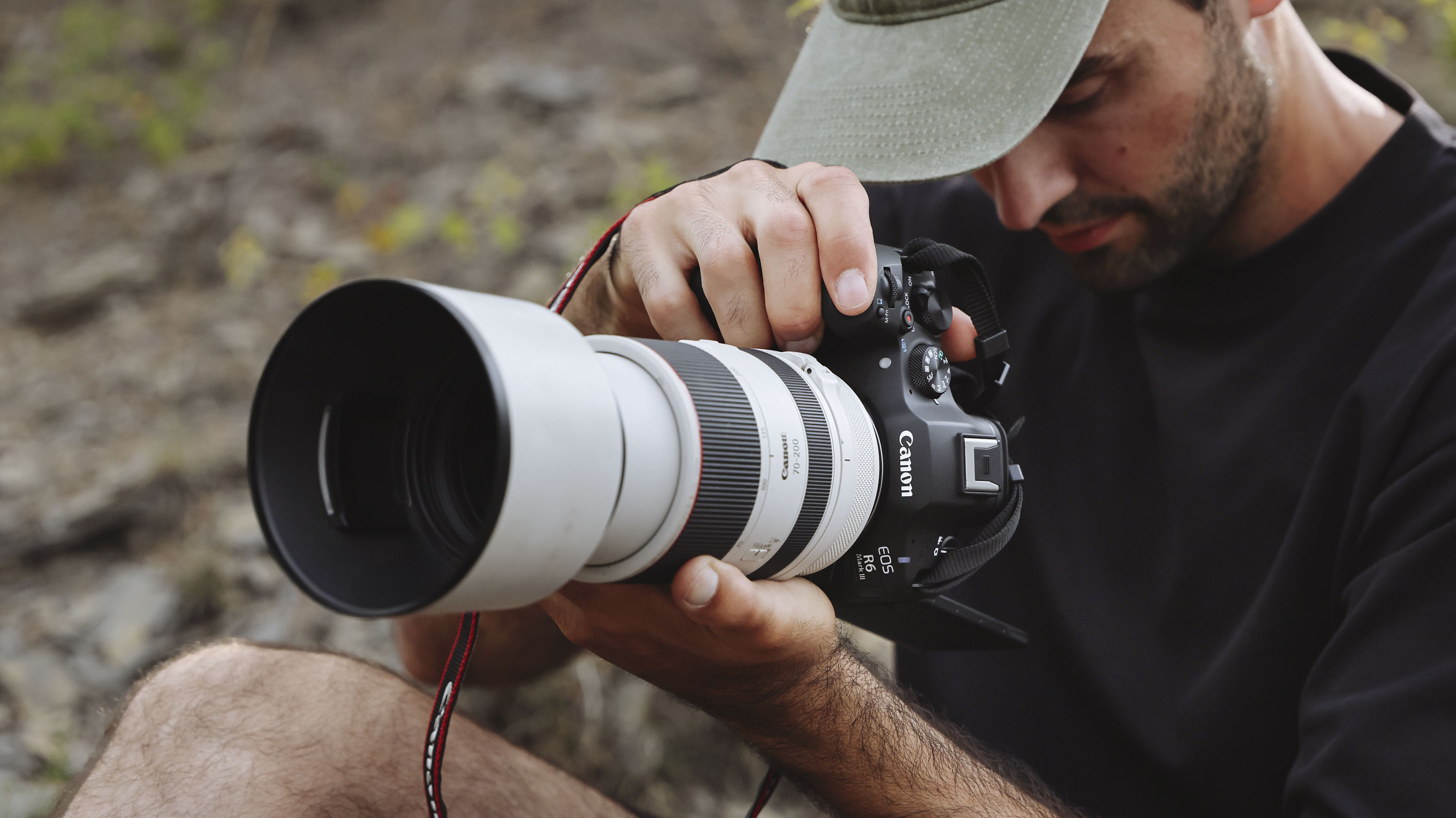 Canon EOS R6 Mark III camera with telephoto lens attached, held by male photographer in vertical orientation