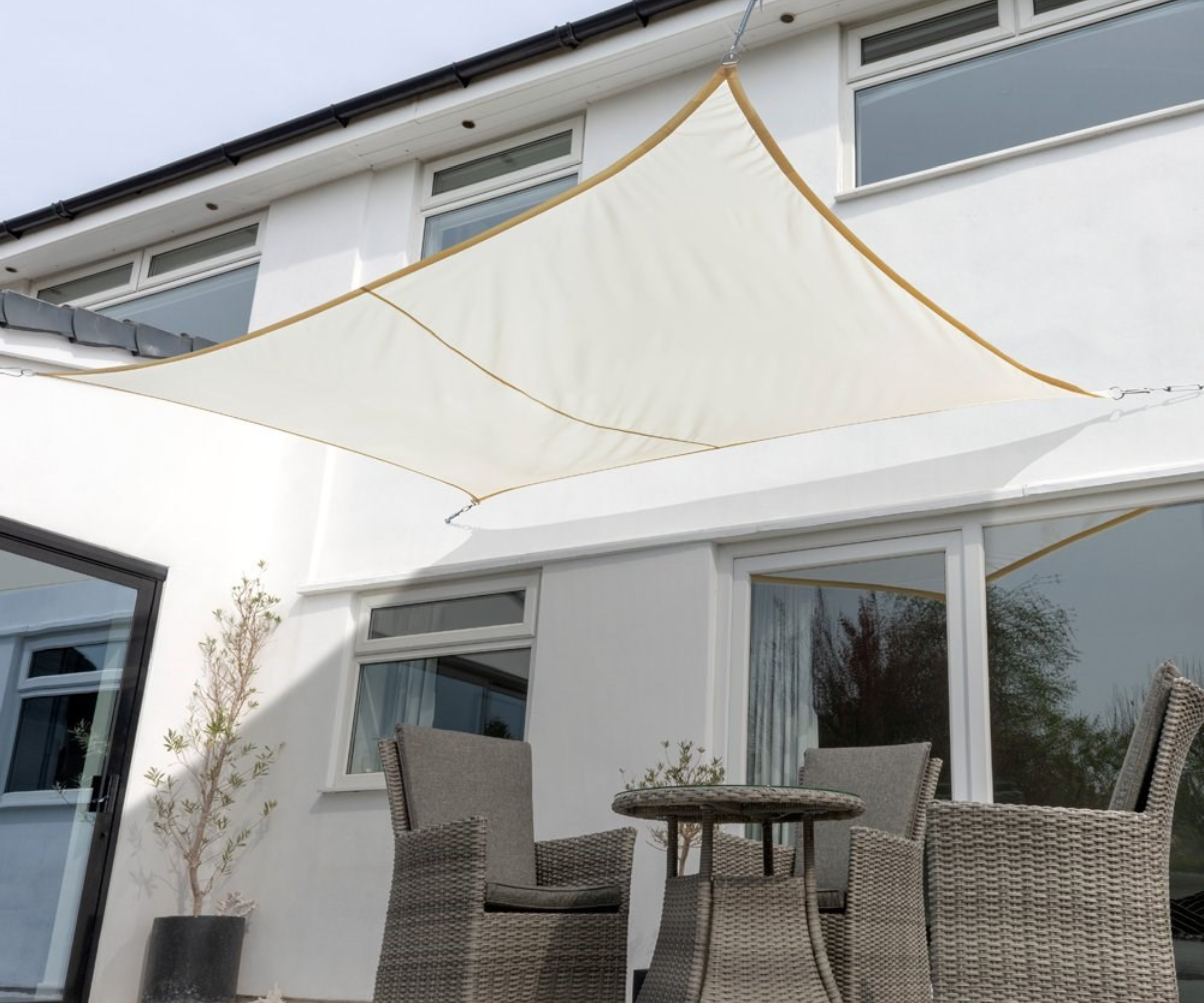 Shade sail above patio doors and garden table set