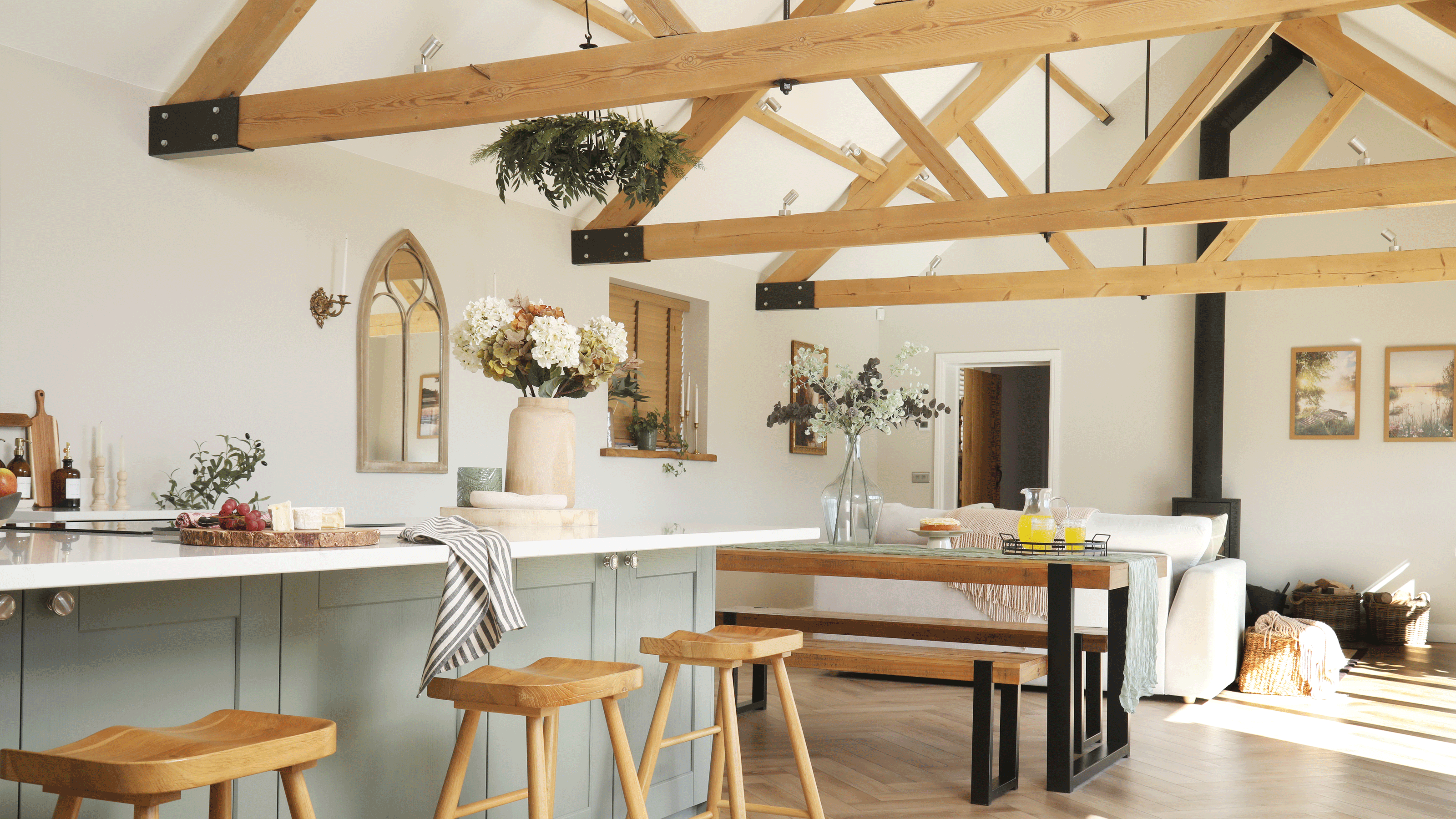 an open plan kitchen dining living space with vaulted ceilings and herringbone flooring