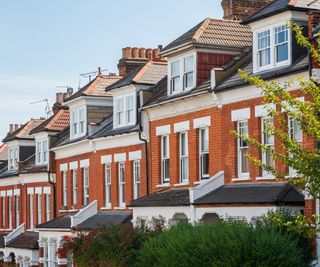 row of brick terraced houses with dormer loft conversions