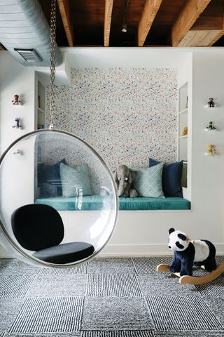 A playroom sleeping berth backed by a confetti-like wallpaper