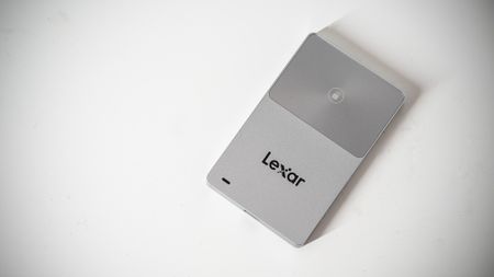 Lexar TouchLock Portable SSD on a white table with a phone.