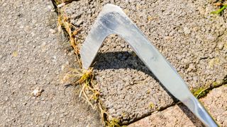 Using a paving knife to remove weeds