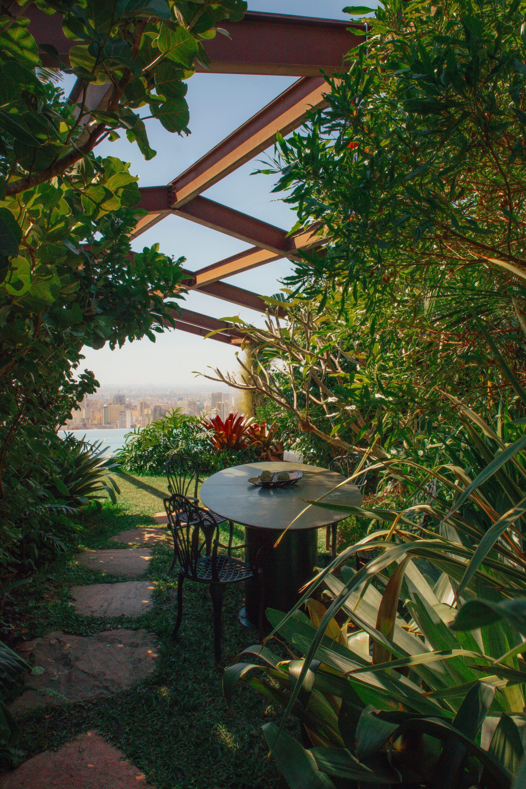 A spectacular, sun-filled penthouse blends Brazilian heritage with sleek surfaces, sculptural furniture, and researched artwork, also incorporating greenery into an earthy scheme.