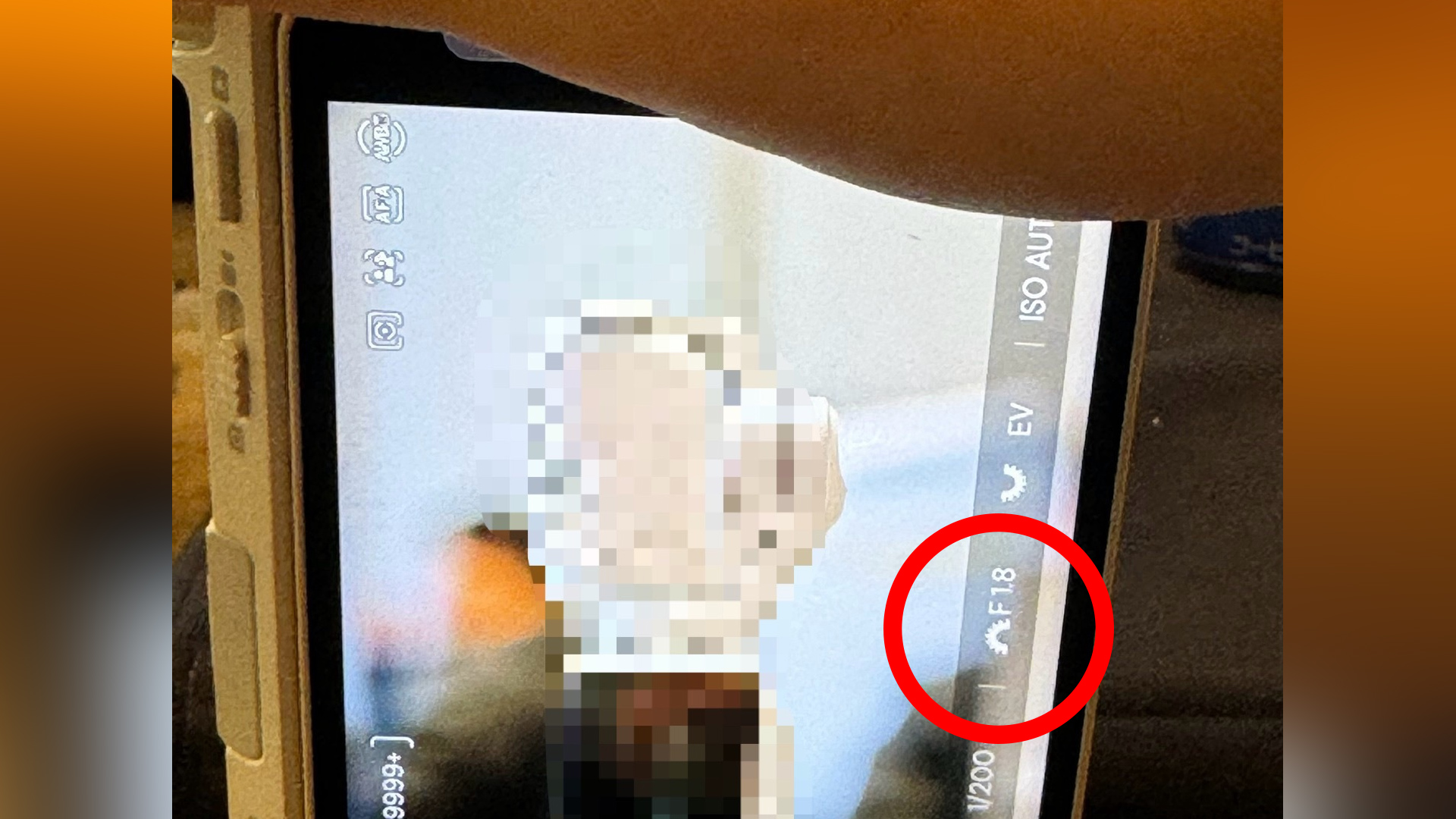 Picture of an unknown camera in hand with a circle highlighting the fact it has an aperture setting