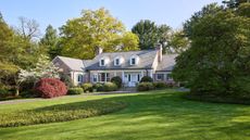 Federal style home with brick facade and luscious lawn