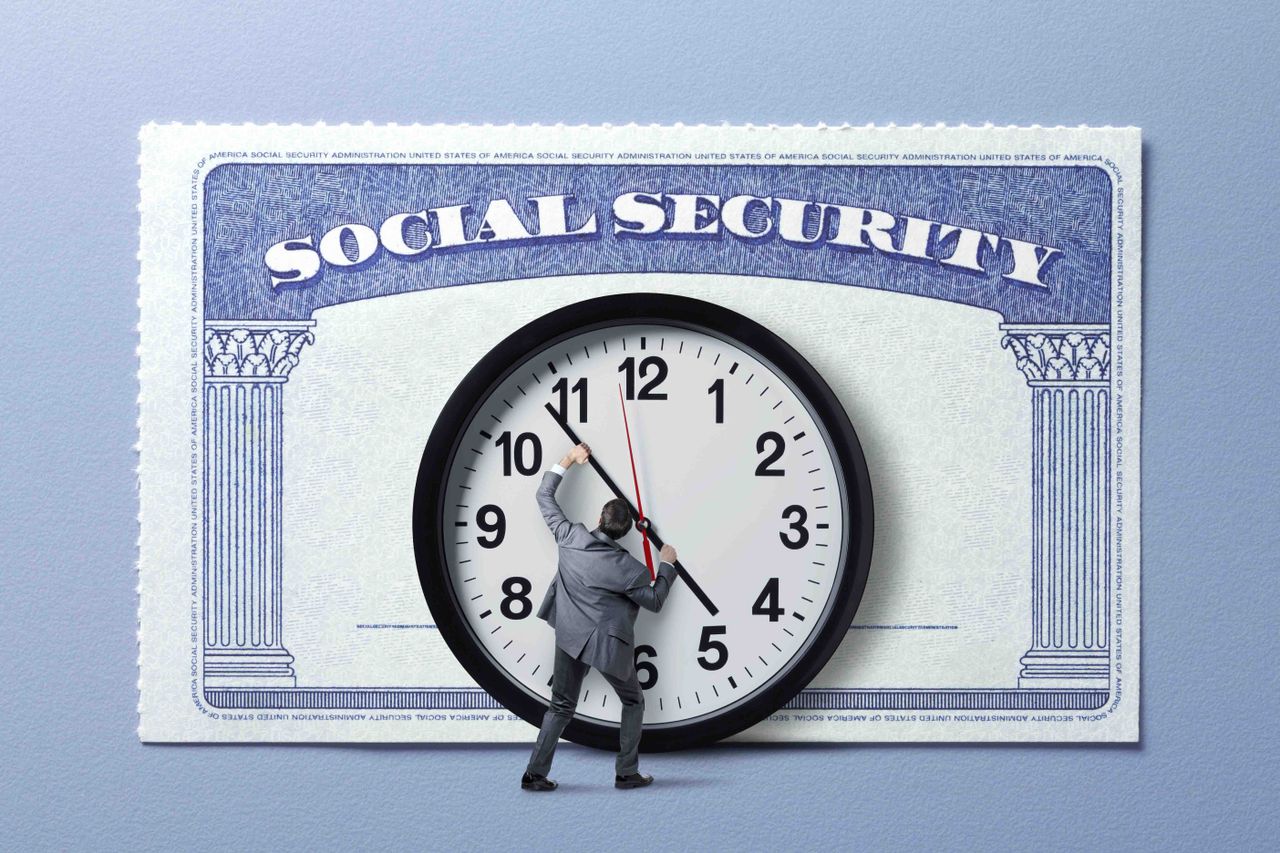 A man moving a giant clock&#039;s hands in front of a Social Security card.