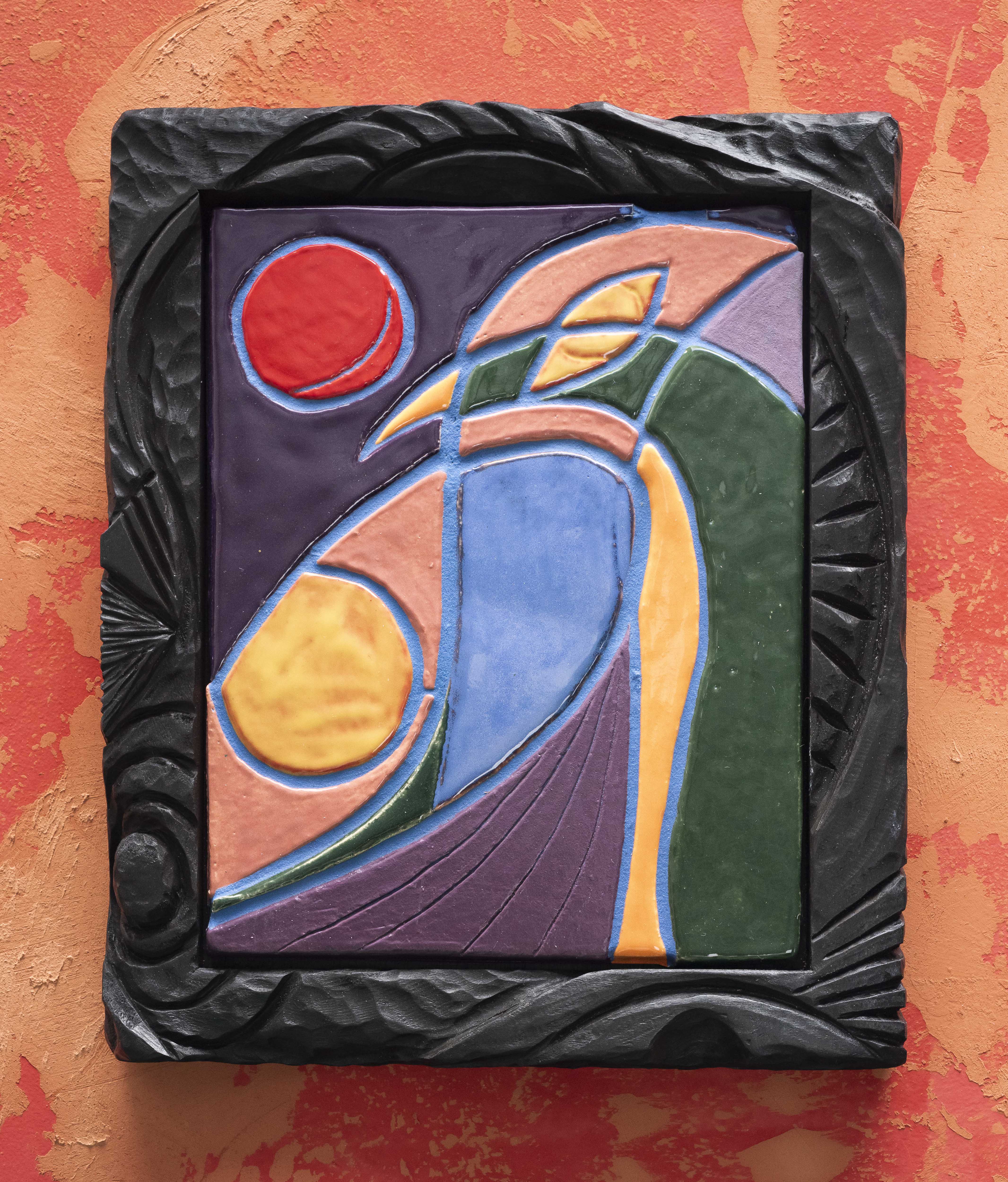 Woody De Othello colourful painted ceramic in carved wood frame on red and orange background
