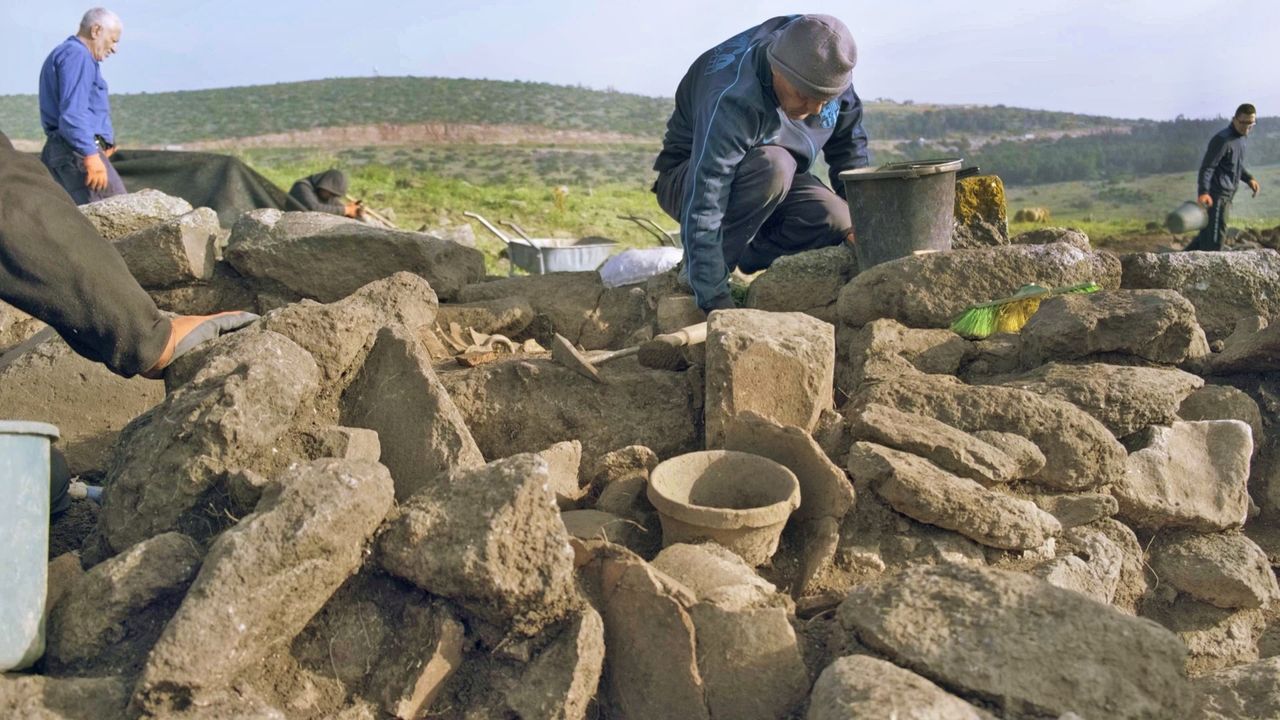 This photo shows a close up of four archaeologists exploring the ruins of an ancient farmstead found in northern Israel.