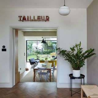 view from a hallway into a dining table space with a long wooden table and eight chairs