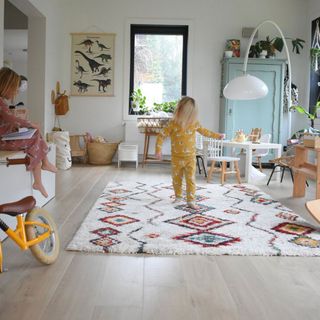 Children playing in a room with a Bowe Moroccan Diamond Cream Rug on top of a wooden floor