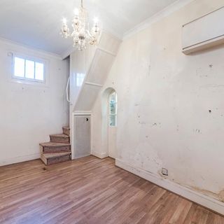 room with white wall wooden steps and wooden flooring
