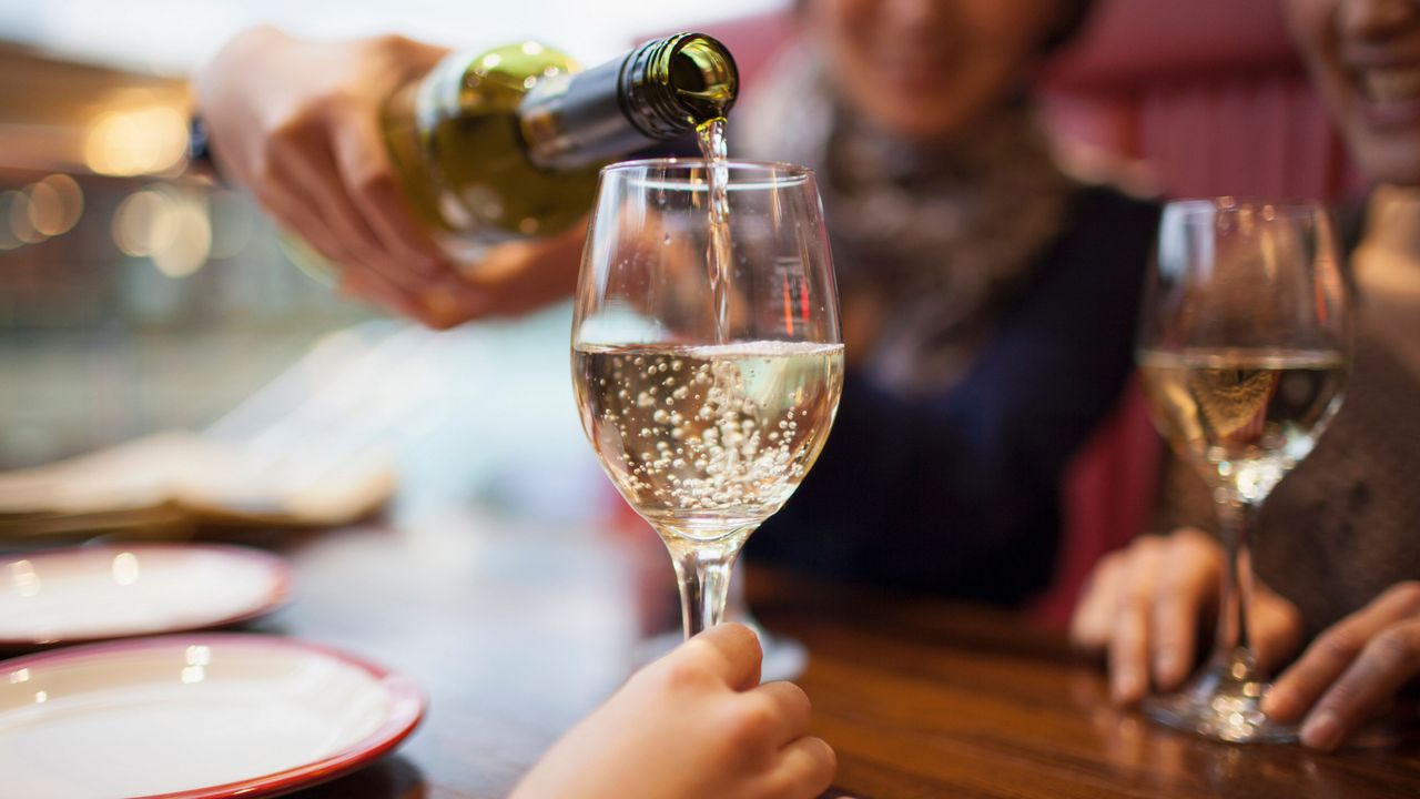 A friend pouring a glass of wine