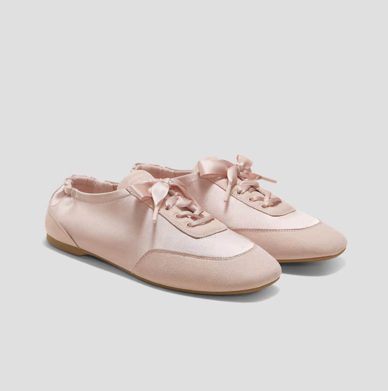 a pair of vivaia ballet sneakers in front of a plain backdrop