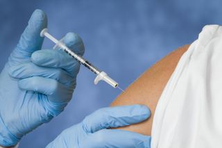 Flu shot being injected into patient.