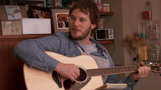 Chris Pratt with a guitar in Lil Sebastian episode of Parks and Rec