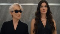 From left to right: Meryl Streep as Miranda and Anne Hathaway as Andy in The Devil Wears Prada 2. They're standing in an elevator and Mirdanda is wearing sunglasses while talking to Andy. 