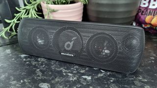 An Anker SoundCore Motion+ Bluetooth speaker, in a kitchen in front of some delicious peanuts.