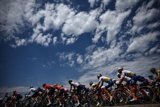 The pack of riders cycles in the French Alps during the 15th stage of the 110th edition of the Tour de France cycling race, 179 km between Les Gets Les Portes du Soleil and Saint-Gervais Mont-Blanc, in eastern France, on July 16, 2023. (Photo by Anne-Christine POUJOULAT / AFP)