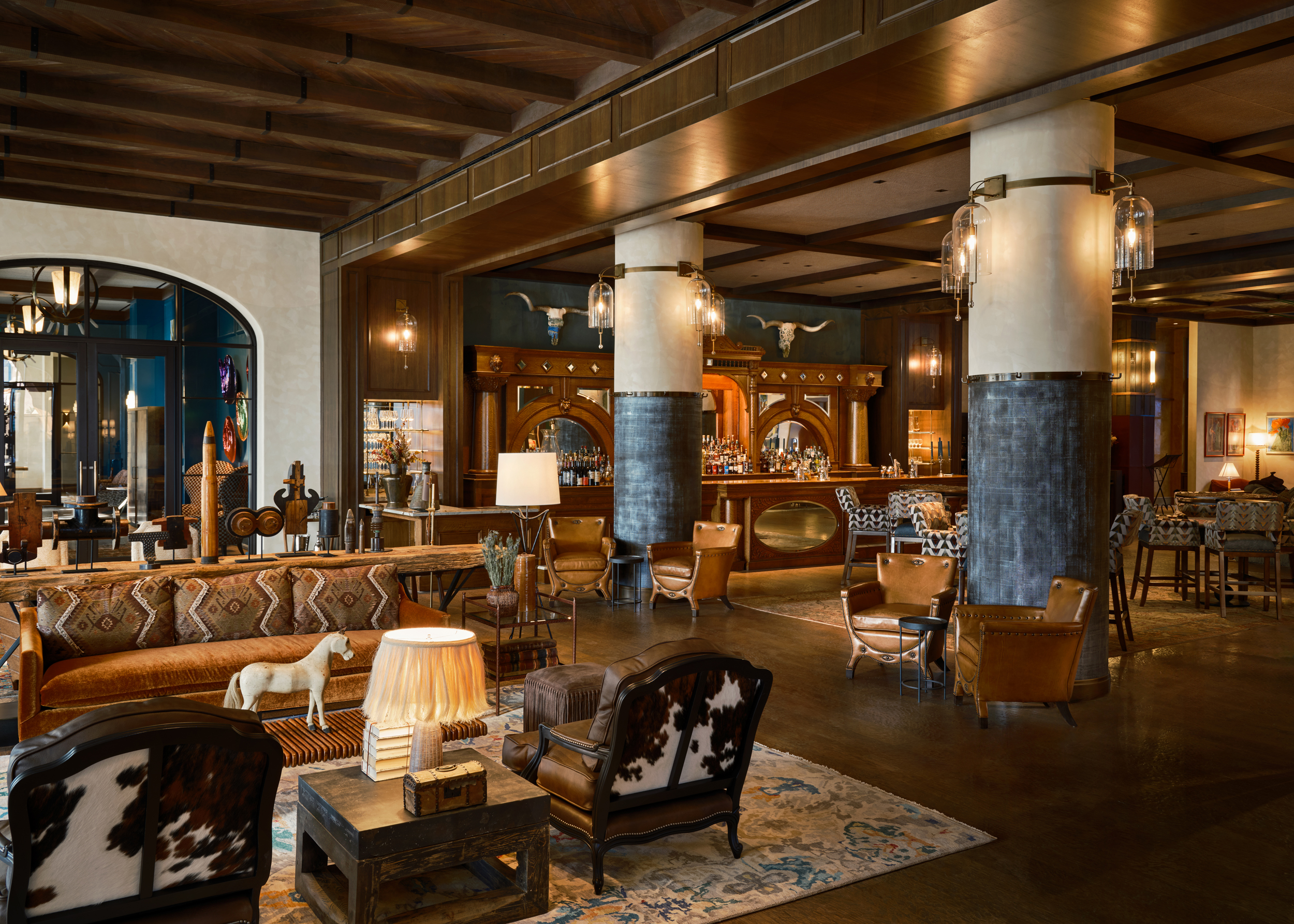 The lobby of Bowie House with cow-print chairs and a horse statue on a table