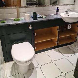 bathroom with green cabinet and mirror